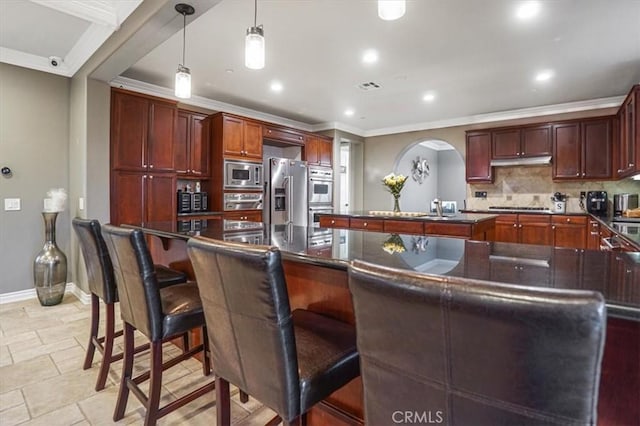 200 Cross Rail Ln, Norco, CA 92860 - kitchen with stainless steel appliances, ornamental molding, baseboards, a large island, and arched walkways