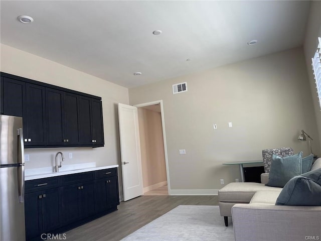 living room with visible vents, wood finished floors, baseboards, and recessed lighting