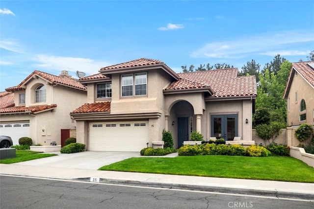 15 Saltillo, Rancho Santa Margarita, CA 92688 - mediterranean / spanish-style home with an attached garage, french doors, concrete driveway, a tile roof, and stucco siding