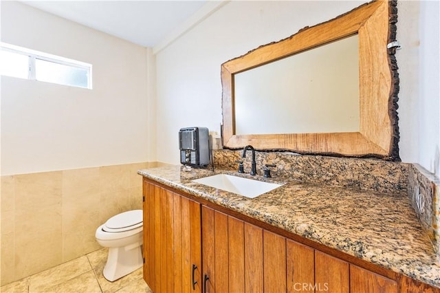 40481 Sage Rd, Hemet, CA 92544 - half bathroom featuring toilet, tile walls, tile patterned flooring, wainscoting, and vanity
