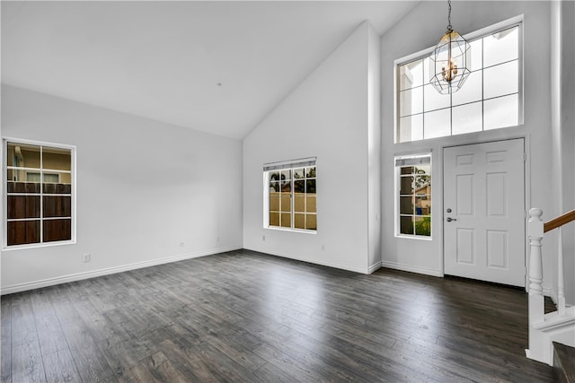 entrance foyer featuring stairs, high vaulted ceiling, dark wood-type flooring, a chandelier, and baseboards