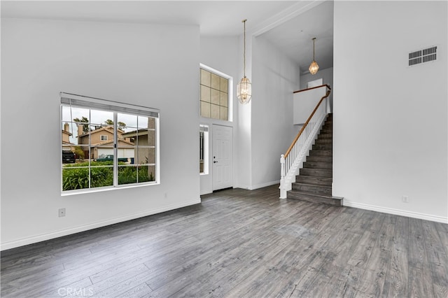 unfurnished living room with wood finished floors, high vaulted ceiling, stairway, baseboards, and visible vents