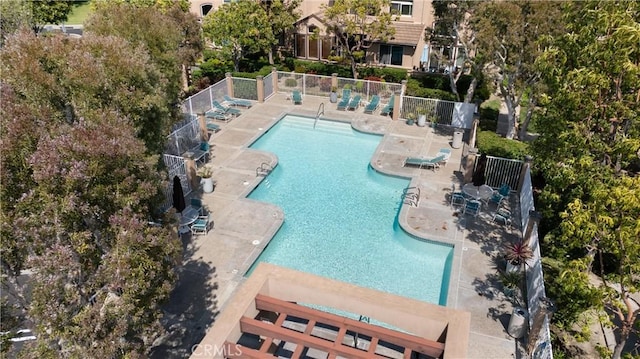 community pool with fence and a patio