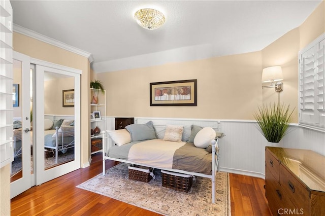 living area with french doors, wood finished floors, wainscoting, and ornamental molding