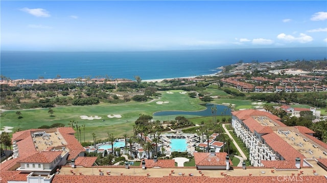 drone / aerial view with view of golf course and a water view