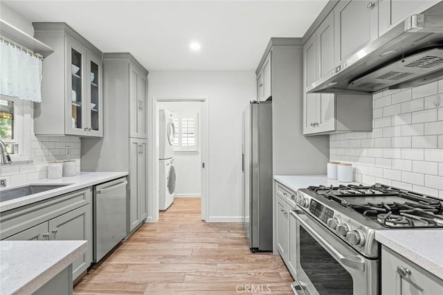 204 E Floral Ave, Arcadia, CA 91006 - kitchen featuring stainless steel appliances, under cabinet range hood, gray cabinetry, stacked washer / dryer, and recessed lighting