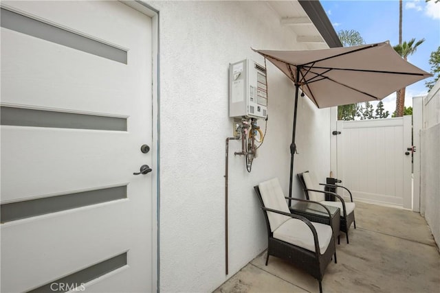 view of patio featuring a gate and water heater