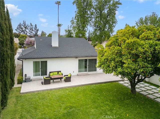 rear view of property with a yard, a patio area, a shingled roof, and stucco siding