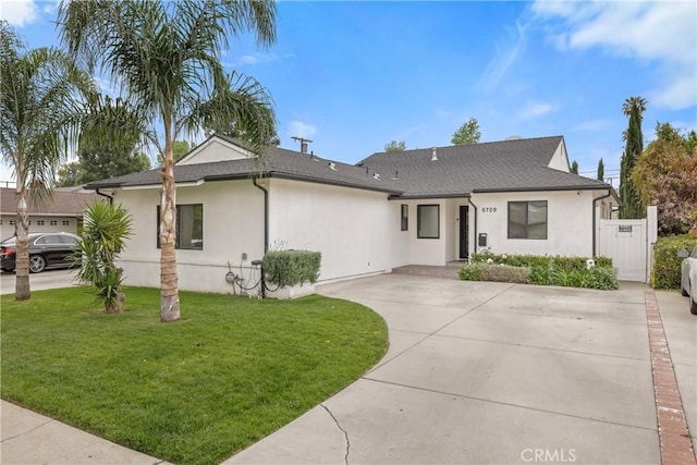 ranch-style home with roof with shingles, concrete driveway, stucco siding, and a front lawn