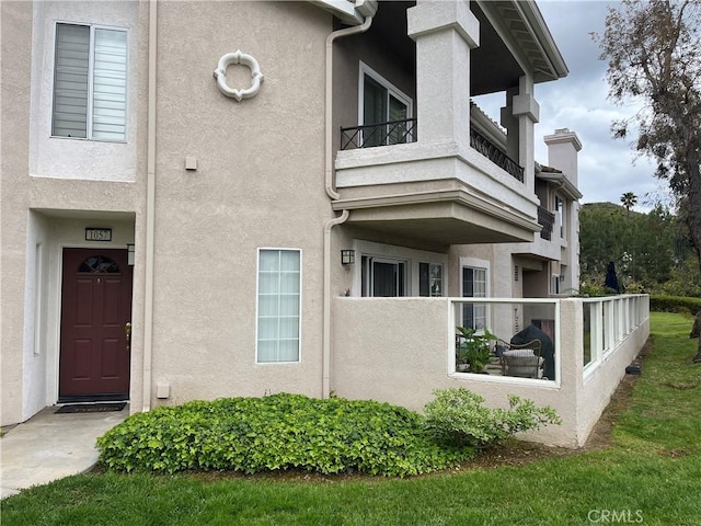 exterior space featuring stucco siding, fence, and a balcony