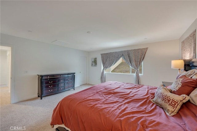 carpeted bedroom with visible vents and baseboards