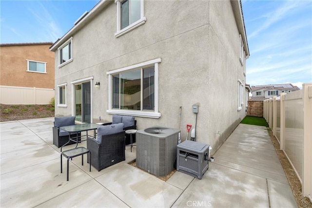 back of house featuring central air condition unit, a patio, stucco siding, and a fenced backyard