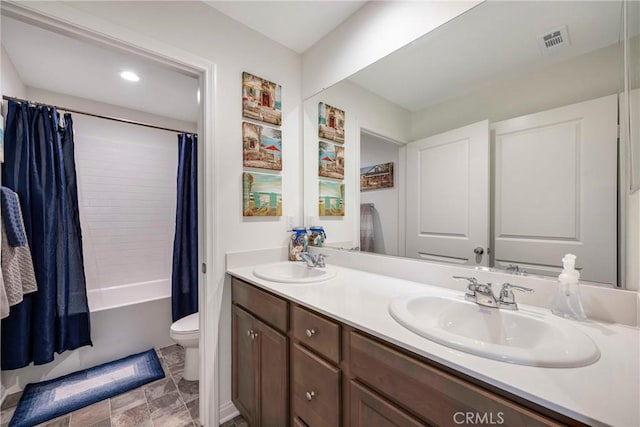 full bathroom with a sink, double vanity, toilet, and visible vents
