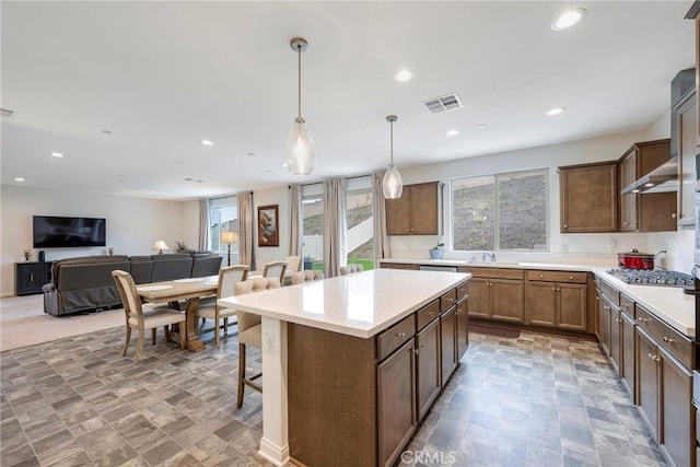 kitchen with a breakfast bar area, open floor plan, visible vents, a kitchen island, and recessed lighting