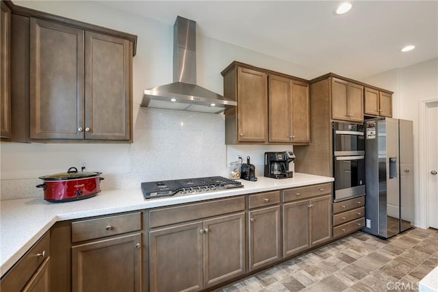 kitchen featuring recessed lighting, light countertops, appliances with stainless steel finishes, and wall chimney exhaust hood
