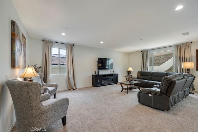 living area featuring light carpet, recessed lighting, and baseboards