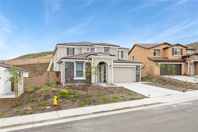 traditional home with driveway, stucco siding, a tile roof, and stone siding
