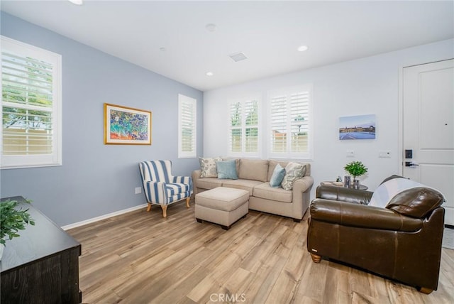 living room featuring a wealth of natural light, light wood-style flooring, baseboards, and recessed lighting