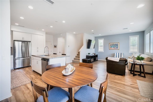 dining area with recessed lighting, light wood-style floors, visible vents, and stairs