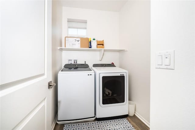 laundry room with baseboards, laundry area, washer and dryer, and wood finished floors