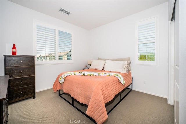 carpeted bedroom featuring baseboards and visible vents