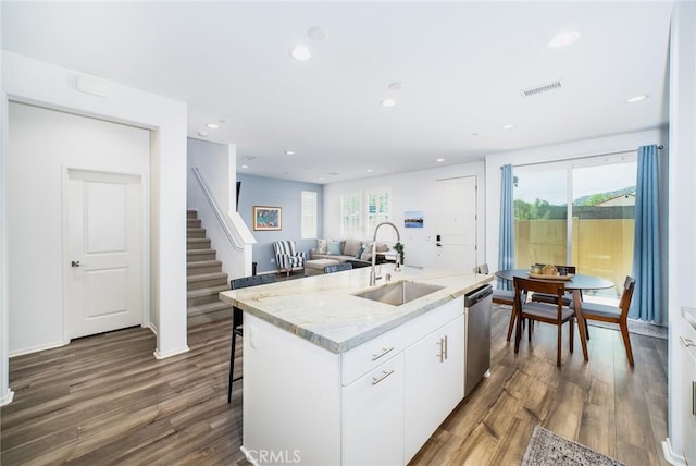 kitchen with stainless steel dishwasher, visible vents, a sink, and dark wood-type flooring