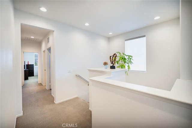hallway with light carpet, recessed lighting, an upstairs landing, and visible vents