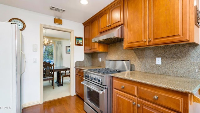 10424 Mcvine Ave, Sunland, CA 91040 - kitchen featuring high end stove, under cabinet range hood, freestanding refrigerator, a chandelier, and dark wood-style floors