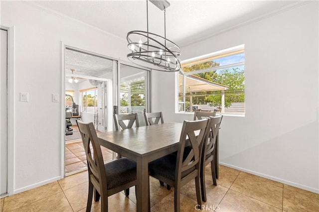 dining area featuring ornamental molding, light tile patterned flooring, baseboards, and a chandelier