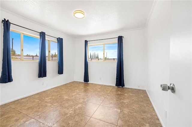 tiled empty room featuring baseboards and crown molding