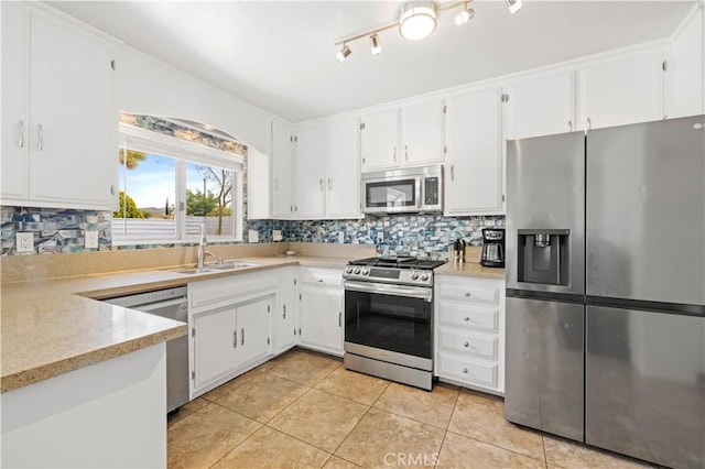 kitchen featuring a sink, light countertops, appliances with stainless steel finishes, decorative backsplash, and light tile patterned flooring