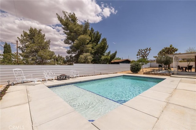 outdoor pool with a patio area and a fenced backyard