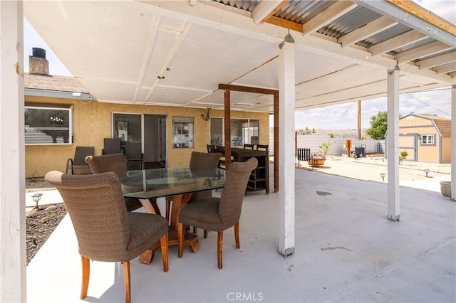 view of patio / terrace featuring outdoor dining area, an outdoor structure, and a shed