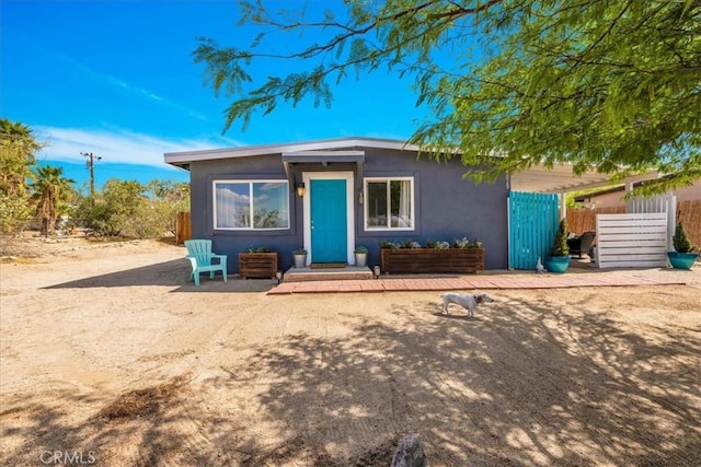 74825 Alta Loma Dr Unit 29, Palms, CA 92277 - view of front facade with fence and stucco siding