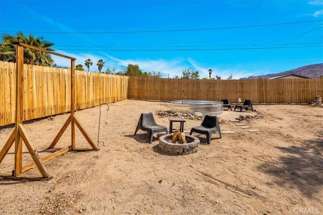 74825 Alta Loma Dr Unit 29, Palms, CA 92277 - fenced backyard with an outdoor fire pit and a mountain view