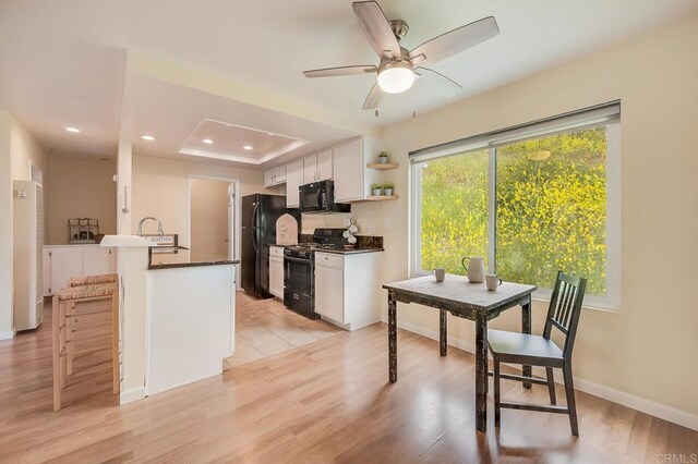 552 Canyon Dr Unit 15, Oceanside, CA 92054 - kitchen with black appliances, dark countertops, white cabinets, a breakfast bar area, and recessed lighting