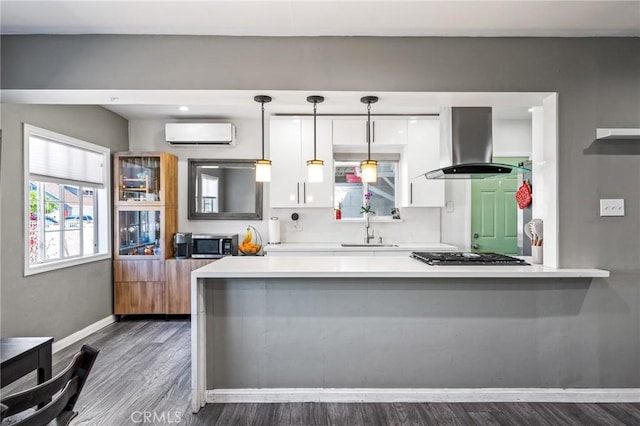 22702 Menlo Ave, Torrance, CA 90502 - kitchen with stainless steel microwave, island exhaust hood, a wall mounted AC, a sink, and white cabinetry