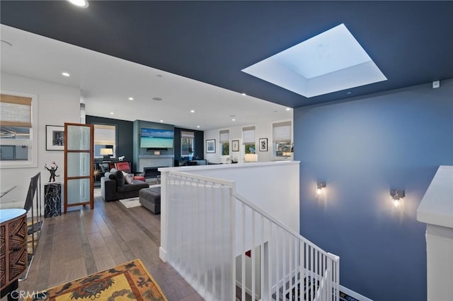 staircase with a skylight, recessed lighting, and wood finished floors