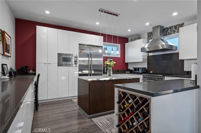 kitchen with built in appliances, dark wood-type flooring, range hood, a kitchen island, and modern cabinets