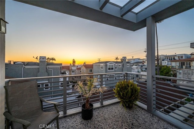 balcony at dusk featuring a residential view