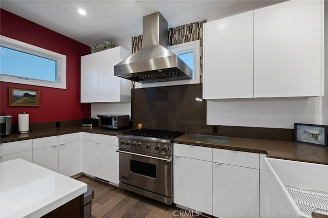 kitchen featuring extractor fan, dark wood-style flooring, white cabinets, and stainless steel range