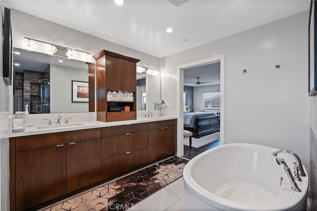 bathroom featuring double vanity, a freestanding bath, a stall shower, and a sink
