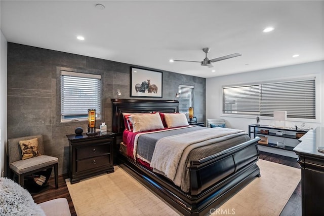 bedroom featuring tile walls, light wood-style flooring, a ceiling fan, and recessed lighting