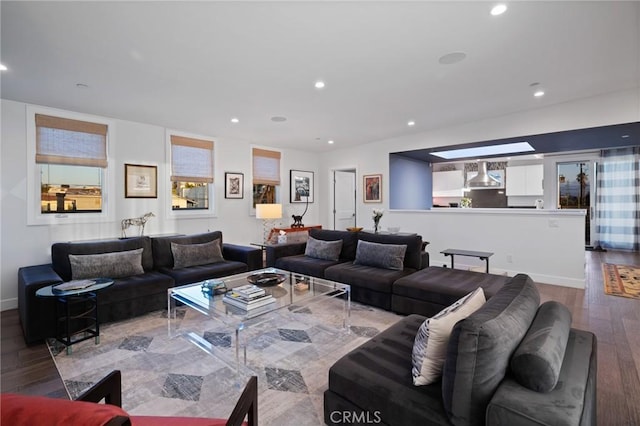 living area featuring baseboards, recessed lighting, and wood finished floors