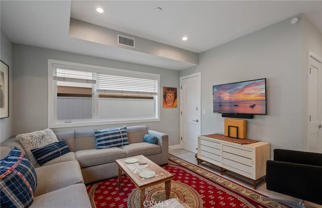 living room with baseboards, visible vents, and recessed lighting