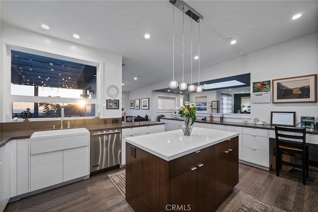 kitchen featuring stainless steel dishwasher, a kitchen island, modern cabinets, dark wood-type flooring, and white cabinets
