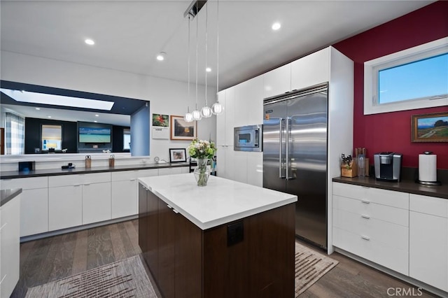 kitchen with built in appliances, modern cabinets, white cabinets, and dark wood-type flooring