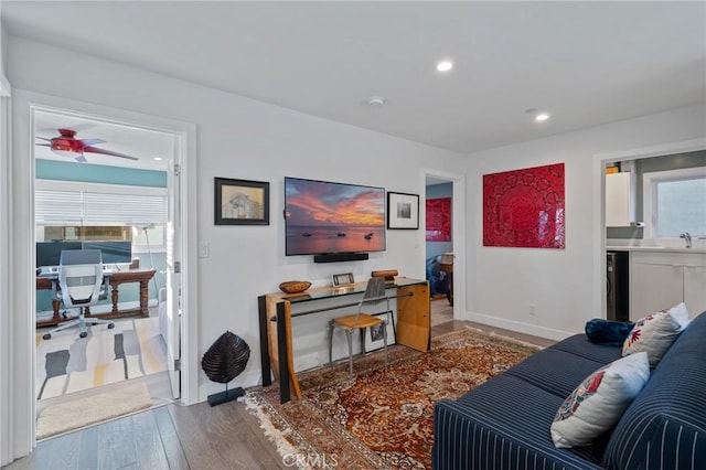 office with wood finished floors, a ceiling fan, a sink, baseboards, and recessed lighting