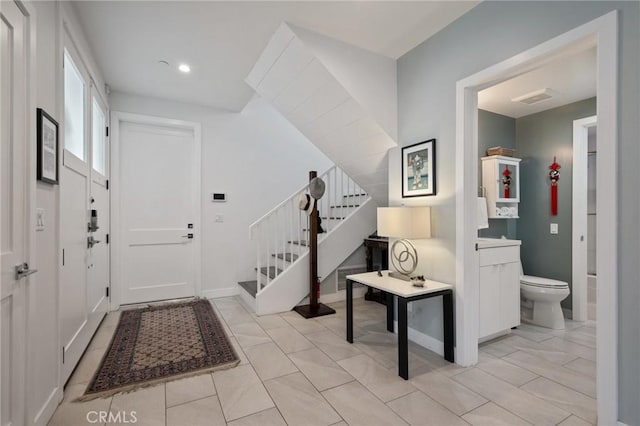 foyer with baseboards, recessed lighting, stairway, and visible vents