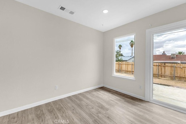 unfurnished room with light wood-style floors, visible vents, baseboards, and recessed lighting